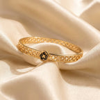 Elegant Gold-Tone Stainless Steel Bangle Bracelet with Black Clover Charm